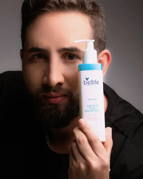 Sample frame: Bearded man holding a skincare bottle in studio light